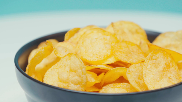 Enfoque selectivo de chips girando en tazón negro - Metraje, vídeo