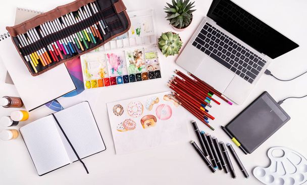 Arbeitsbereich für Künstler oder Designer mit Laptop, Tablet und Zeichenwerkzeugen - Foto, Bild