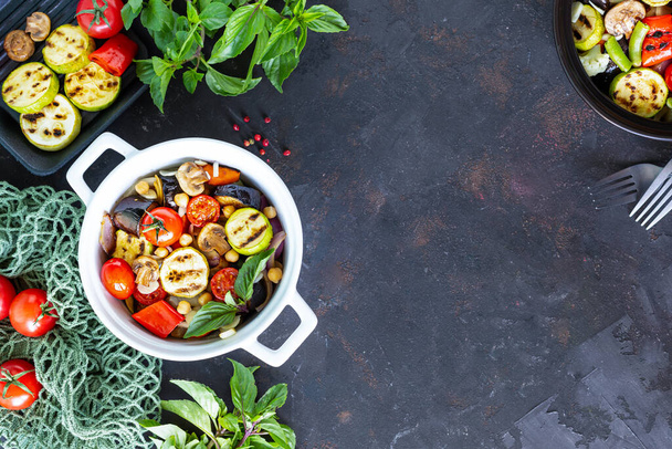 Ernährung, richtige Ernährung, gegrilltes Gemüse und Zutaten auf dunklem Hintergrund. Rahmen. Vegetarisches Essen. Ansicht von oben. Kopierraum - Foto, Bild