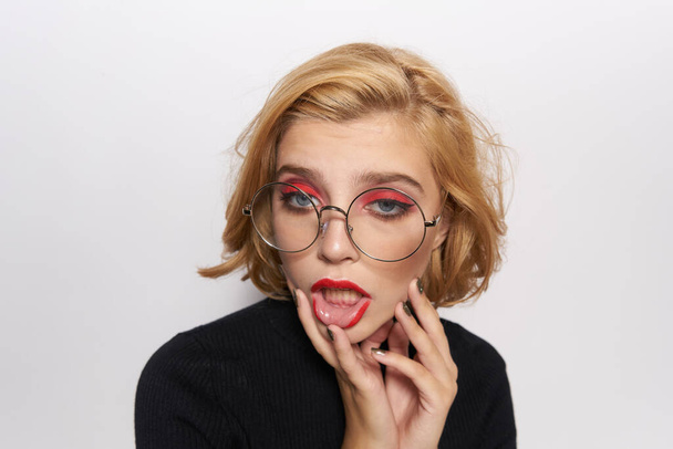 Cute blonde in glasses bright makeup black jacket cropped view light background emotions - Photo, Image