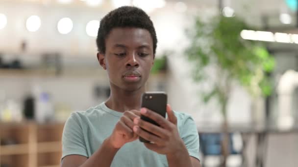 Nuori Afrikkalainen mies käyttää älypuhelinta, Tekstiviestit - Materiaali, video