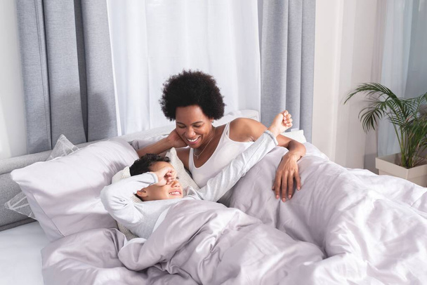 Mother with son waking up in bed - Photo, image