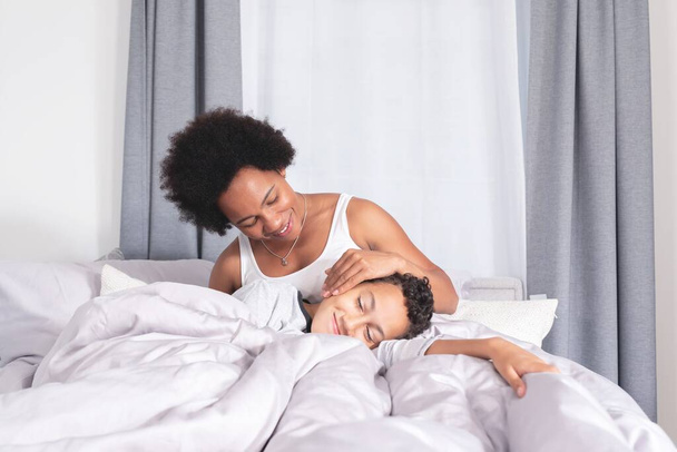 Happy mother with son sleeping in bed - Foto, afbeelding
