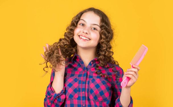 Hairstyle for party. Hairdresser supplies. Little child curly hair. Fashion and beauty. Small girl hairdresser salon. Brushing long hair. Enjoying shiny curls. Balm oil conditioner for styling - Fotoğraf, Görsel