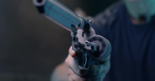 Неузнаваемый человек перезаряжает револьвер в тире - Кадры, видео