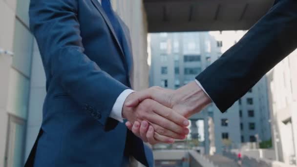 Sluiten van de handen van topmanagers in business pakken, handen schudden met elkaar, bij Business center achtergrond, akkoord gaan met een deal of zeg hallo. Slow-motion onherkenbaar persoon - Video