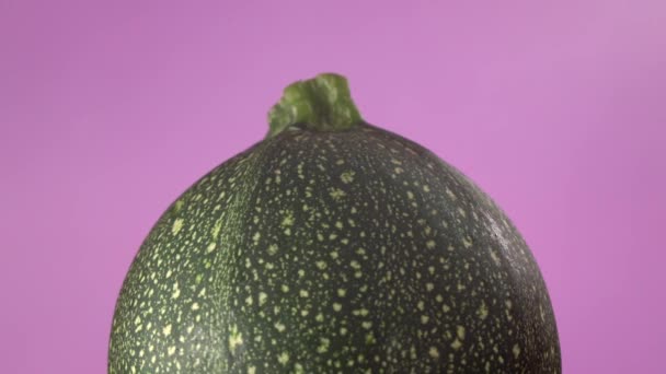 Cukkini lila háttérrel. Kreatív forgó makró felvétel friss és egészséges zöldségekről - Felvétel, videó
