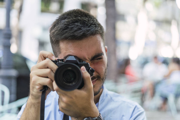 A shallow focus shot of a young European male with a photo camera - Foto, immagini