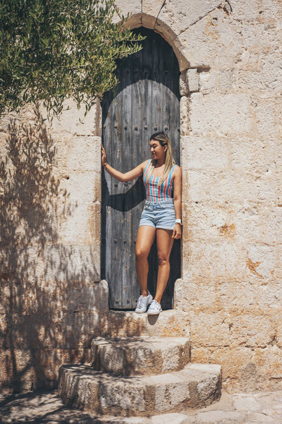 A vertical shot of a young Hispanic female posing on the Peniscola castle in Spain - 写真・画像
