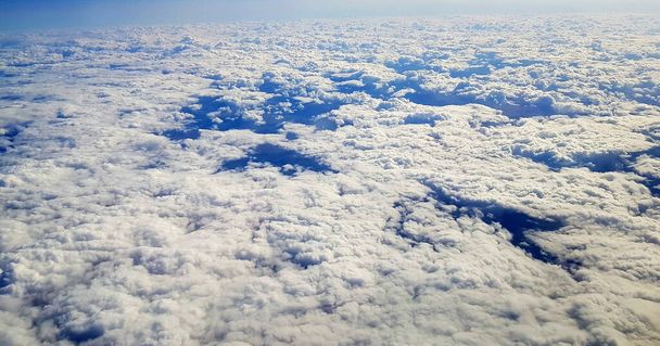 A beautiful scenery of the earth and white clouds seen from a plane - Foto, imagen