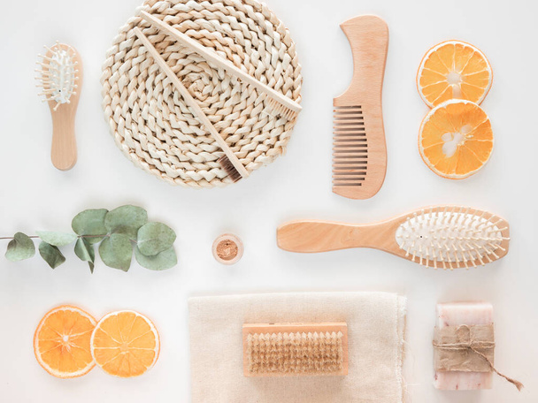 Zero Waste wooden bath accessories concept. Top view craft soap, orange wedges and eucalyptus branch over white background - Photo, Image