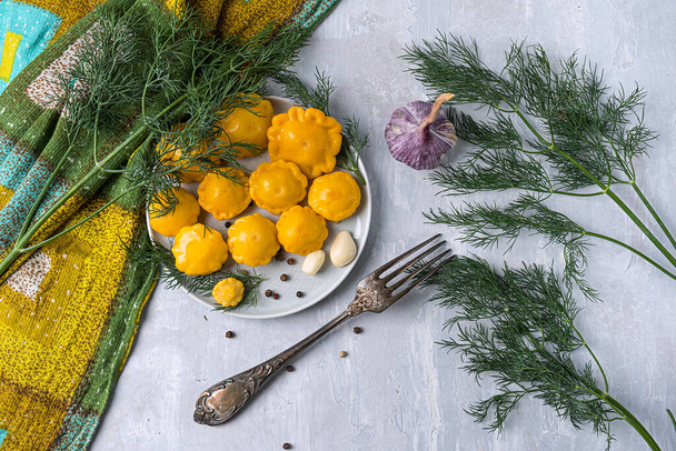 mini-squash marinated with pepper, garlic and dill, homemade. On a light gray stone background. View from above. Copy space - Foto, Imagem