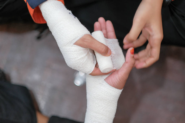 Allenamento di primo soccorso per studenti in sala. Studente che cerca di steccare la mano di incidente mano rotta di un paziente con bendaggio elastico al college. - Foto, immagini