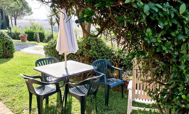 elegáns pihenőhely a kertben székekkel és asztallal egy szabadtéri reggelihez - Fotó, kép