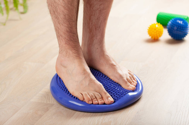homme faisant correction des pieds plats exercice gymnastique équilibrage sur coussin de massage à la maison - Photo, image