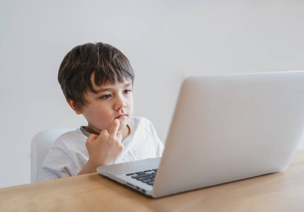 Kid self isolation using tablet for his homework,Child doing using digital tablet searching information on internet during covid 19 lock down,Home schooling,Social Distance,E-learning online education - Zdjęcie, obraz