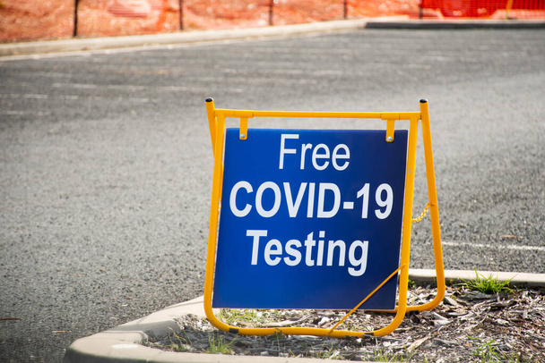 Test COVID-19 gratuito. Guidare attraverso il segno clinica test su una strada. - Foto, immagini
