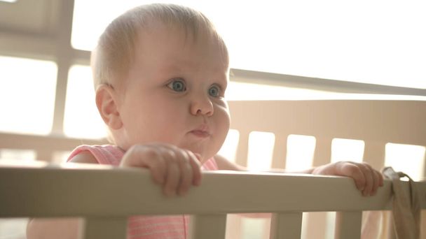 Cute baby standing in cot. Cute childhood. Toddler girl in crib - Photo, Image