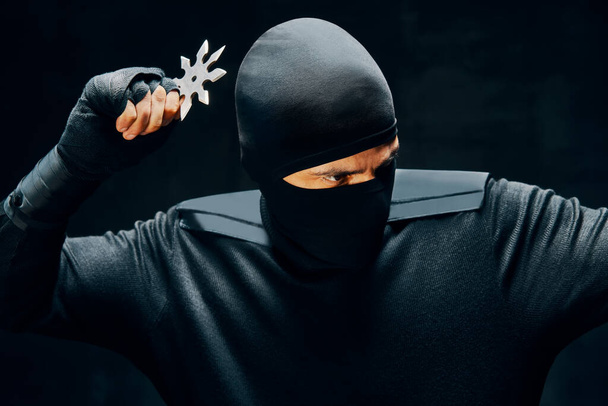 Ninja with a sword and shuriken ready to stab enemy - Photo, image