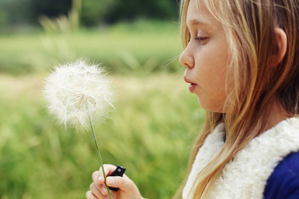 Portrait of cute girl with dandelion outdoor - Photo, Image