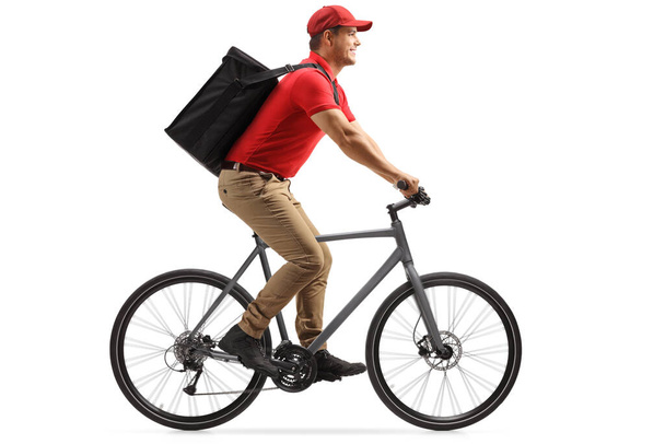 Food delivery guy in a red t-shirt delivering food with a bicycle isolated on white background - 写真・画像