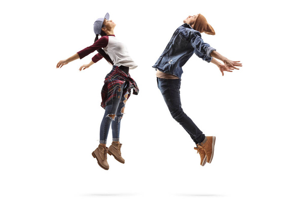 Full length profile shot of a young man and woman performing a dance jump isolated on white background - Foto, afbeelding