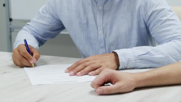 Close-up zakenman hand zet handtekening op papier. Ondertekent een contract in slow motion. - Video
