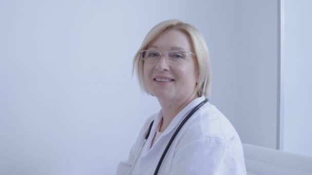 Smiling female doctor looking in camera, medical staff, health care, profession - Felvétel, videó
