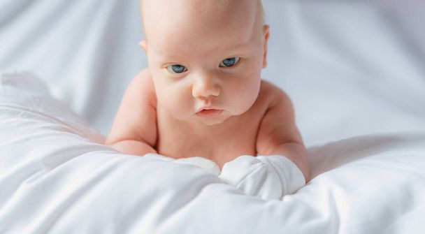 Emotionaalinen vauva leikkii katseella, kun makaa sängyssä - Valokuva, kuva