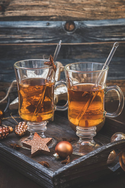 Δύο ποτήρια με τσάι σε ένα χριστουγεννιάτικο διακοσμημένο ξύλινο δίσκο. Κάθετη φωτογραφία αποθέματος. - Φωτογραφία, εικόνα