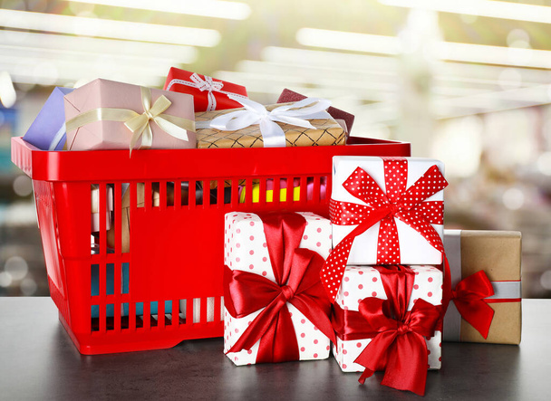 Boxing day concept. Shopping basket with gifts in supermarket - Foto, afbeelding
