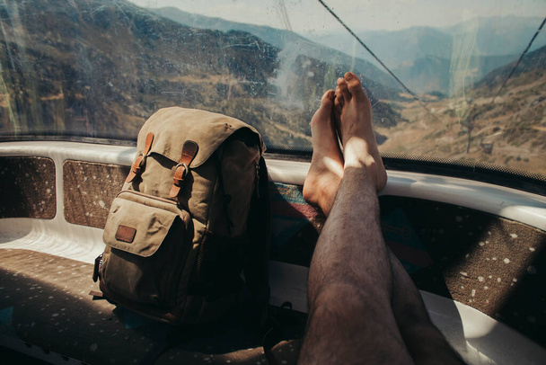Рюкзак и скрещенные ноги внутри канатной дороги в Андорре. - Фото, изображение