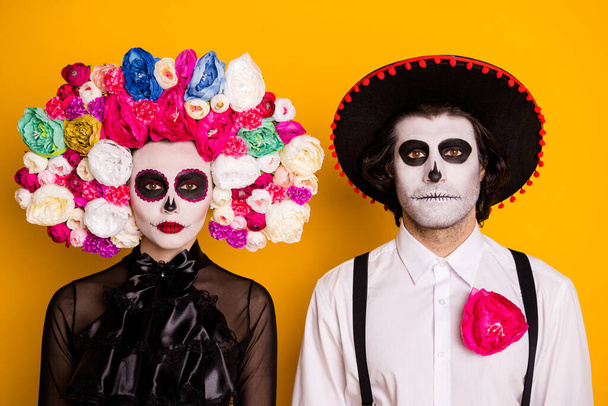 Photo of charming undead couple man lady serious follow necromancer command find sacrifice wear black dress death costume roses headband suspenders sombrero isolated yellow color background - Foto, imagen