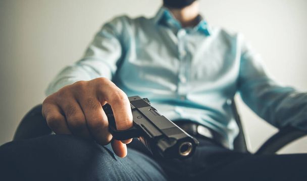 sitting man hand gun in home - Photo, Image