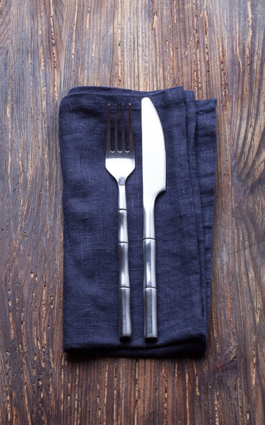 tenedor y cuchillo una servilleta azul sobre un tablero de madera vintage
 - Foto, Imagen