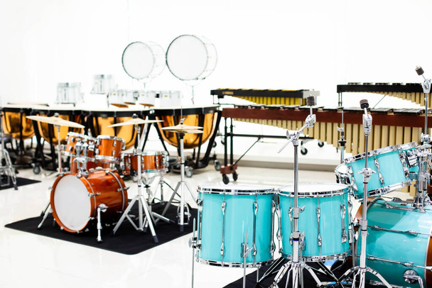 Selectieve focus op drumstel met wazig marcherend bandinstrument in muzikale showroom in muziekinstrumentenwinkel. - Foto, afbeelding