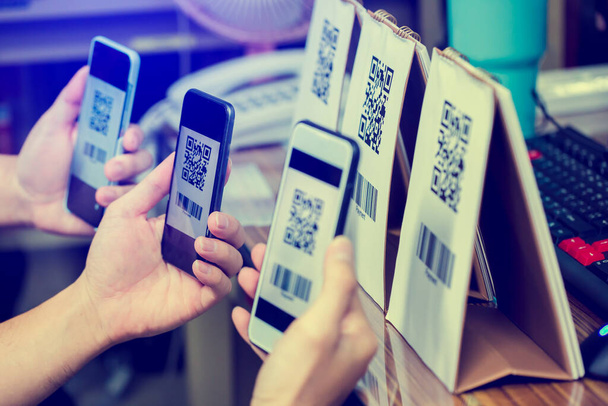 Birçok müşteri QR kodu ödemelerini ve barkodlarını taramak için akıllı telefonu tutuyor. Dijital ödeme ve online alışveriş kavramı. - Fotoğraf, Görsel