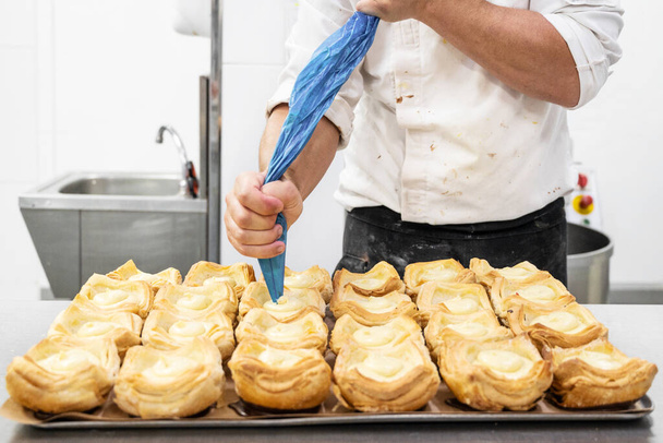 Шеф-кондитер украшает пирог кремом из кондитерской сумки крупным планом - Фото, изображение