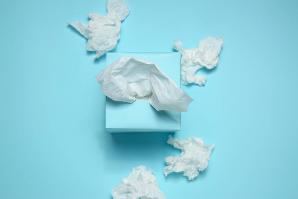 Used paper tissues and box on light blue background, flat lay - Φωτογραφία, εικόνα