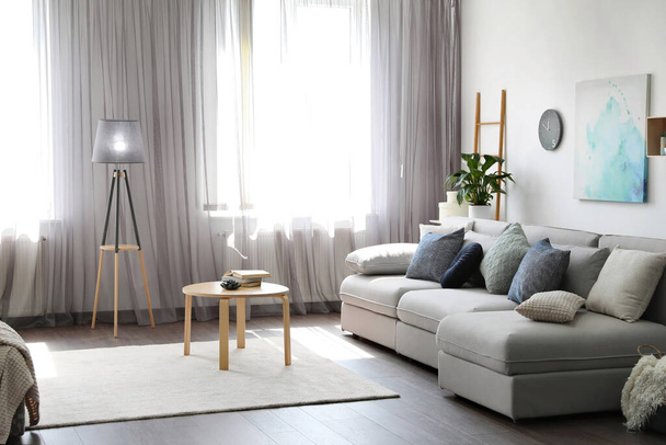 Elegant living room with comfortable sofa near window. Interior design - Foto, afbeelding