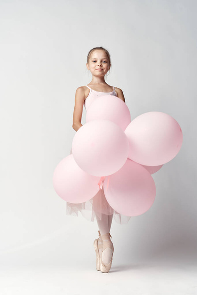 ballerina girl in costume with balloons in hands tutu pointe shoes dance - Foto, imagen