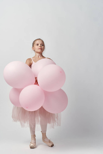 ballerina girl in costume with balloons in hands tutu pointe shoes dance - Fotó, kép