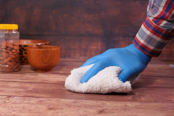 рука в синіх гумових рукавичках прибиральний стіл з тканиною
  - Фото, зображення