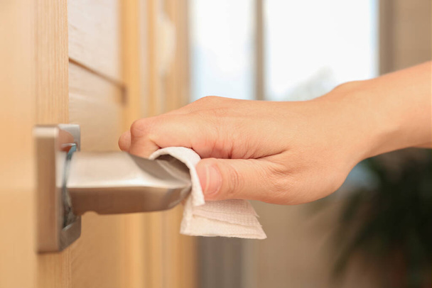 Woman using tissue paper to open door, closeup - Fotografie, Obrázek