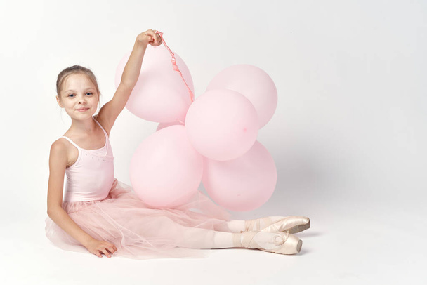 ballerina girl in costume with balloons in hands tutu pointe shoes dance - Fotografie, Obrázek