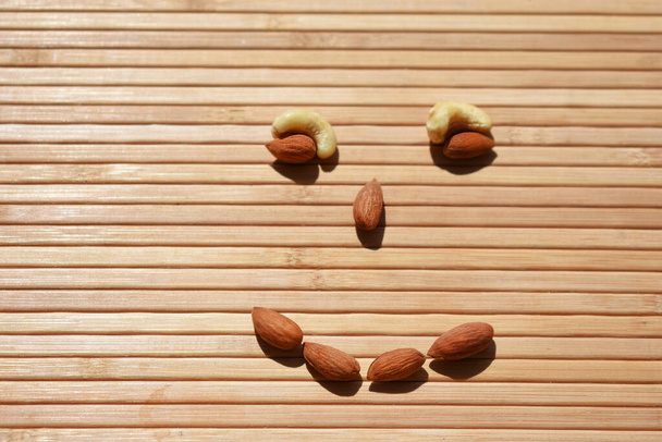 almond nut face  on wooden surface - Фото, изображение