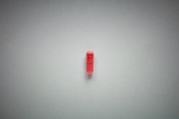 one red pill on a plain background - Zdjęcie, obraz