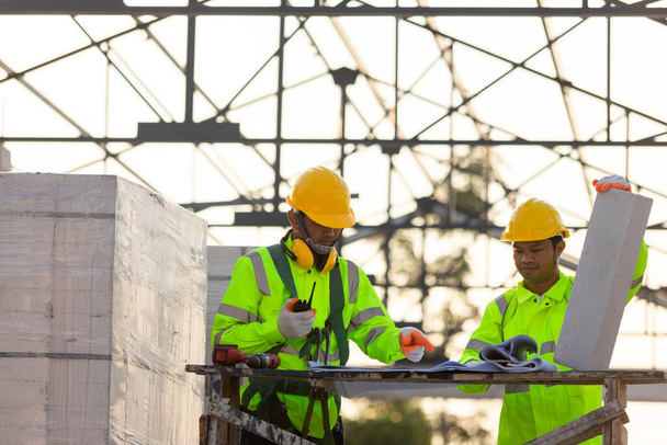 Ingenieros asiáticos y trabajadores consultores calculan la cantidad de ladrillos utilizados en la construcción, Concepto de trabajo en equipo de construcción. - Foto, Imagen
