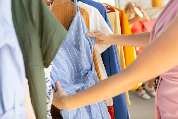 Wear, clothing shop during sales, summer or autumn collection. Young women looking for new attire - 写真・画像