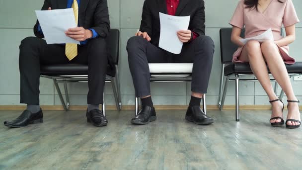  Arbeitslose Geschäftsleute und Bewerber sitzen in einer Reihe von Stühlen in der Schlange und warten auf ihr Vorstellungsgespräch. Sie sehen gestresst und unruhig aus, weil sie einen Job in einer freien Stelle, Personalressourcen, Rekrutierung und Beschäftigungskonzept brauchen - Filmmaterial, Video